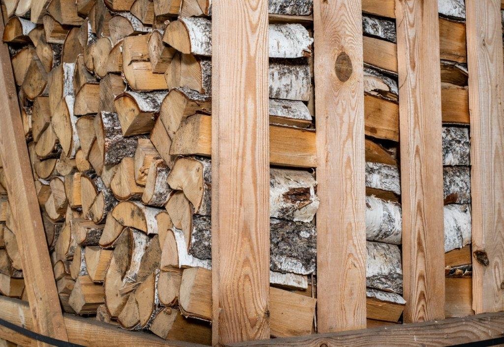 Gestapeltes Birkenbrennholz in der Lagerbox des Betriebs